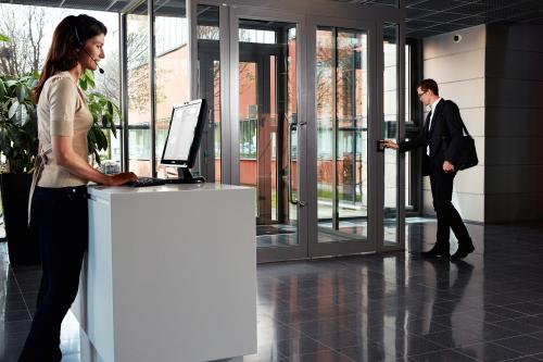 Woman at front desk and man exiting building